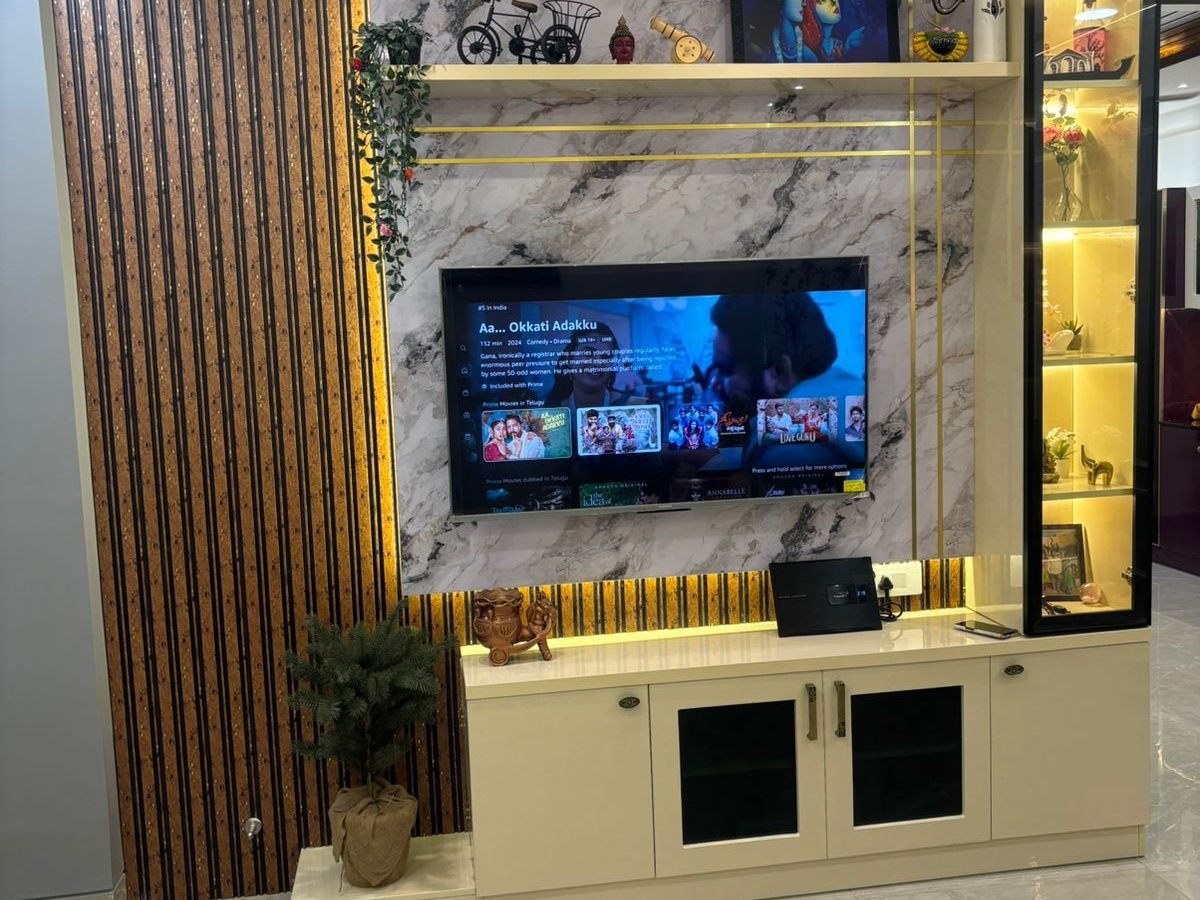 TV wall in marble and fluted wood with a lit glass display cabinet