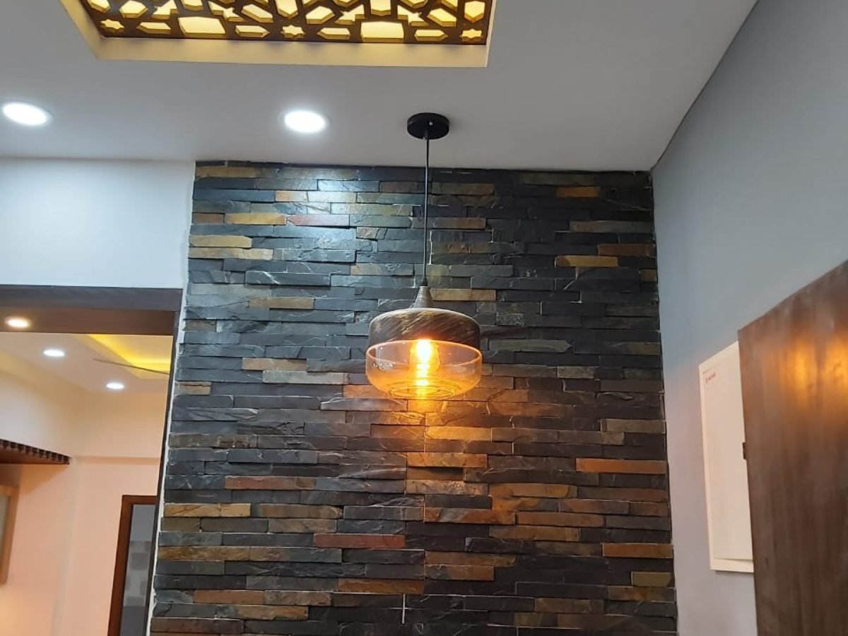 Living room feature wall in stacked stone cladding with a glass pendant light